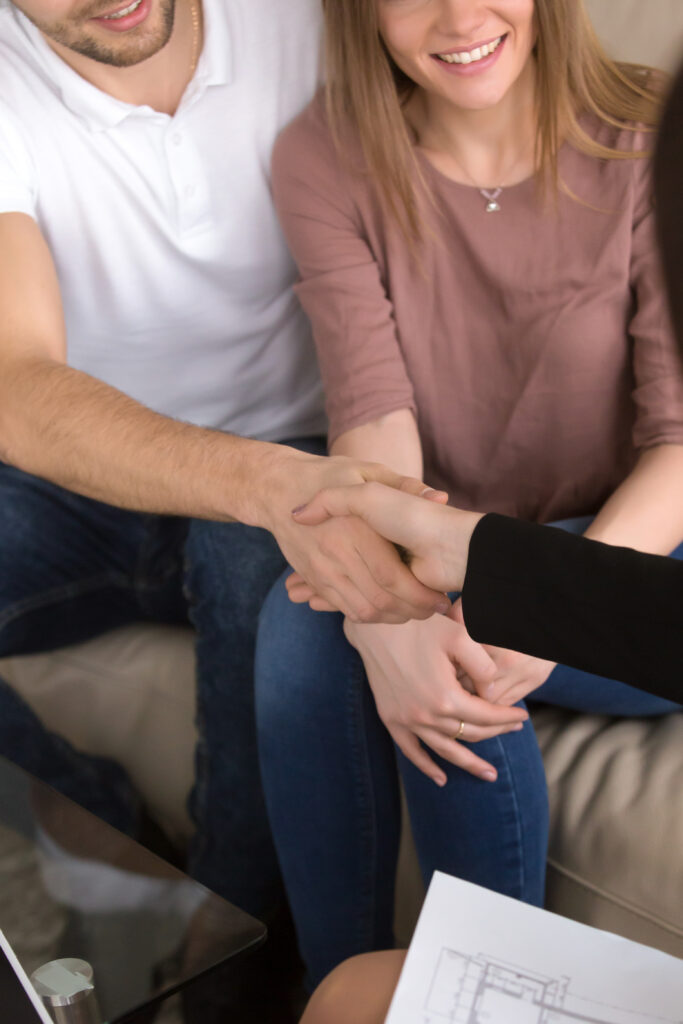 couple shaking hands with realtor. real estate and home renovati